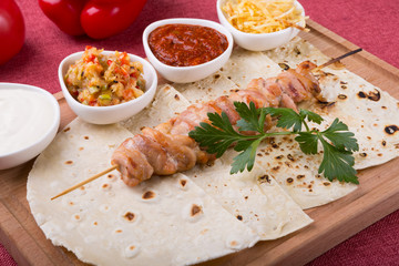 Cooked chicken kebab on a wooden board