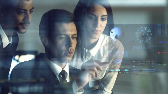 The business people working with a virtual screen with a hologram