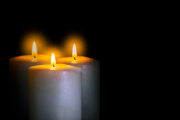 Fototapeta na wymiar burning three candle in the dark