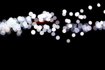Abstract bokeh of white city lights on black background. defocused and blurred many round light