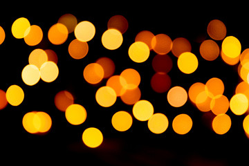 Gold abstract bokeh background. defocused and blurred many round yellow light on dark background