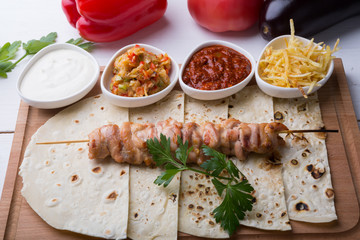 Cooked chicken kebab on a wooden board