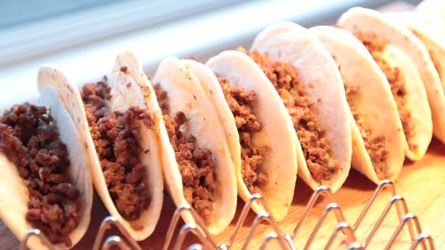 Close up of soft beef tacos on rack left to right