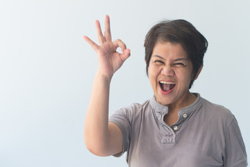 middle aged asian woman giving approving, accepting, yes, ok or okay gesture