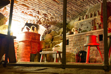 Fototapeta na wymiar Medieval alchemist’s laboratory interiors: bricked vault equipped with vintage alchemical glassware, tools and wooden old-style furniture