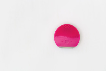 Silicone brush for face wash on white background with copy space. Red elecrtic brush. Beauty...