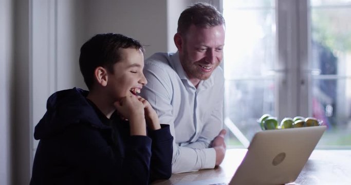 4K Happy dad & son watching funny videos on the internet & reacting to what they see
