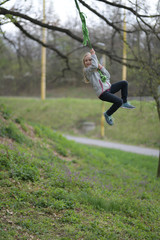 Happy child girl laughing and swinging on a swing