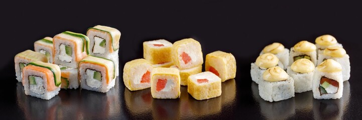 Elite sushi rolls on a black background. Assortment of rolls with different fillings.