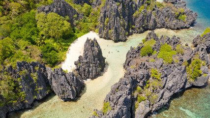 El Nido Palawan National Park Philippines. Warm hidden lagoon near the rocks. Tourists relax on the white beach. Tourist routes in the Philippines. Rocky formations on a tropical beach.
