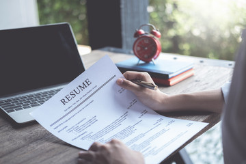 Business man review his resume application on desk, laptop computer, job seeker