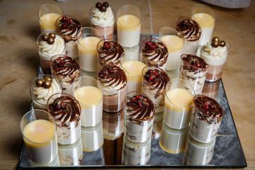 assorted cream mousse dessert in small plastic cups