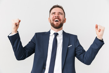 Happy businessman posing isolated over white wall background make winner gesture.