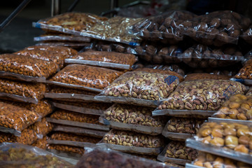 Transparent plastic package full of various dried fruits stacked in piles for sale at market, dried fruits, asian market - Image