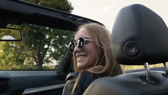 Happy young woman in the cabriolet.