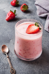 Homemade yogurt with fresh strawberries in glasses on a dark concrete background. Selective focus. Copy space.
