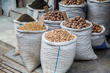 Lots of dried fruits in white sacks for sale at market , variety of dried fruits displayed outside the shop - Image