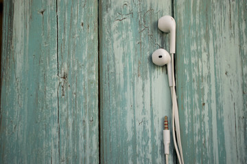 white telephone headphones on a turquoise desktop