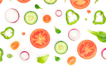 Fresh vegetable salad ingredients, shot from the top on a white background. A flat lay composition with tomato, cucumber, peppers, onion slices and mezclun leaves
