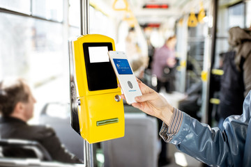 Paying conctactless with smartphone for the public transport in the tram, close-up view