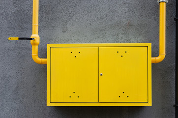 yellow gas pipe with a crane goes along the facade of a new multi-storey building.