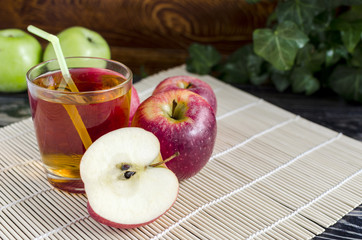 apples red and green Apple juice in a transparent glass on a natural background