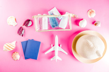 Travel and vacation flatlay concept. Summer bright colorful background with hat, sunglasses, plane,  passport, tropical leaves, travel cosmetics kit, seashells, copy space top view banner
