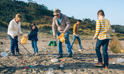 Group of volunteers picking up trash on the beach