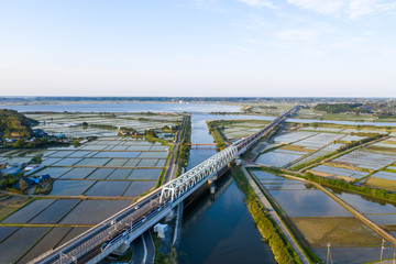 田植え時期の印旛沼を渡る成田空港線の京成スカイライナーを俯瞰撮影