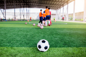 Obraz na płótnie Canvas football on green artificial turf with blurry soccer team training