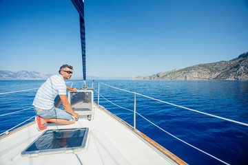 Young man sailing yacht. Holidays, people, travel
