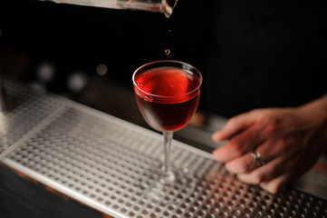 Cherry drops in a cocktail from professional forceps