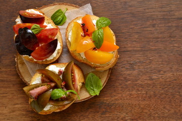 Bruschetta with soft cheese, tomatoes and basil, top view, copy space