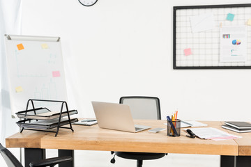 modern office with white board and laptop on wooden desk