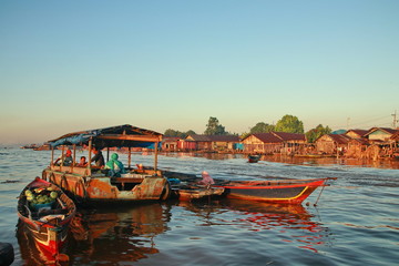 Citra Bahari Barito river floating market in the morning, full of gold from the sunrise in Banjarmasin / South Kalimantan - Indonesia, May 12, 2019