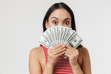 Young pretty asian woman posing isolated over white wall background holding money.