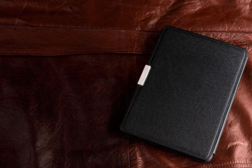 Electronic book in the case on leather background