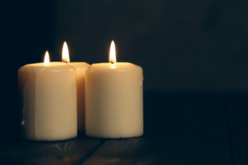 candles burning in darkness over black background. commemoration concept.