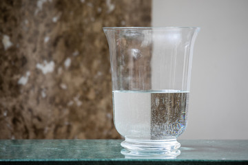 The Vase Without Flowers Is Filled With Water And Reflects The Wall, Forming A Chess Pattern