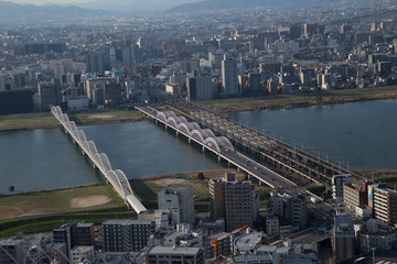Obraz premium River, Bridge and View of Osaka from the Umeda Building at sunset on a sunny day