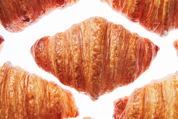 Close up pattern fresh french croissants on a white background.