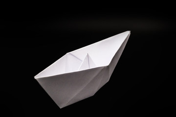 paper boat isolated on black background, handmade paper origami.