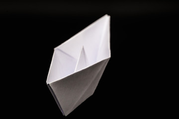 paper boat isolated on black background, handmade paper origami.