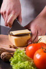 young woman slicing cheese in a gray apron
