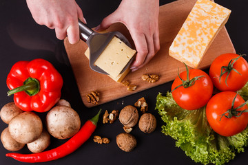 young woman slicing cheese in a gray apron