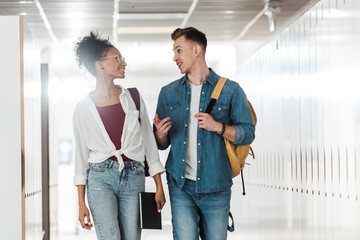 Fototapeta premium two multiethnic students looking at each other in corridor in university