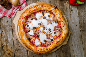 Pizza with tuna and red onion on wooden background
