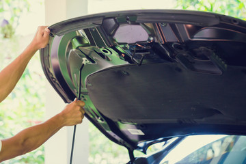 The man opened the hood of car and looking for a malfunction