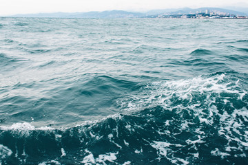 ripples on blue sea water with white foam , natural sea background