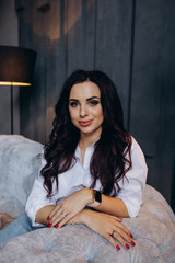 Photo session of a young brunette in jeans and a white shirt.